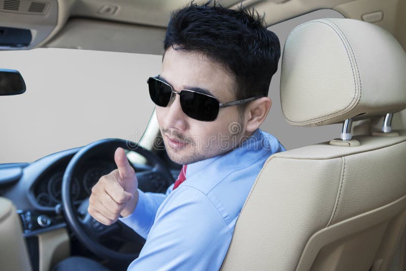 Erfolgreiche Person, die Daumen oben im Auto zeigt stockbilder Erfolgreiche Person, die Daumen oben im Auto zeigt stockbilder
