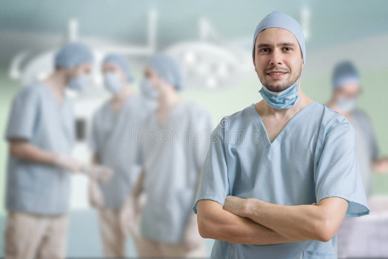Erfolgreicher Chirurg lächelt Viele Chirurgen im Hintergrund