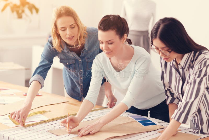 Erfolgreiches Team von den Schneidern, die zusammenarbeiten lizenzfreie stockbilder Erfolgreiches Team von den Schneidern, die zusammenarbeiten lizenzfreie stockbilder