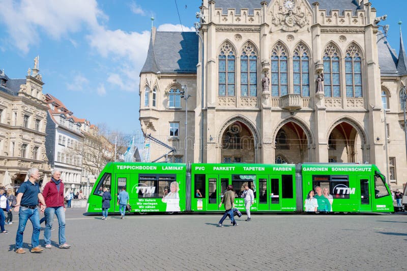 Erfurt Tyskland April 7, 2019 H?rlig gammal arkitektur och en modern gr?n sp?rvagn i centret royaltyfri bild Erfurt Tyskland April 7, 2019 H?rlig gammal arkitektur och en modern gr?n sp?rvagn i centret royaltyfri bild