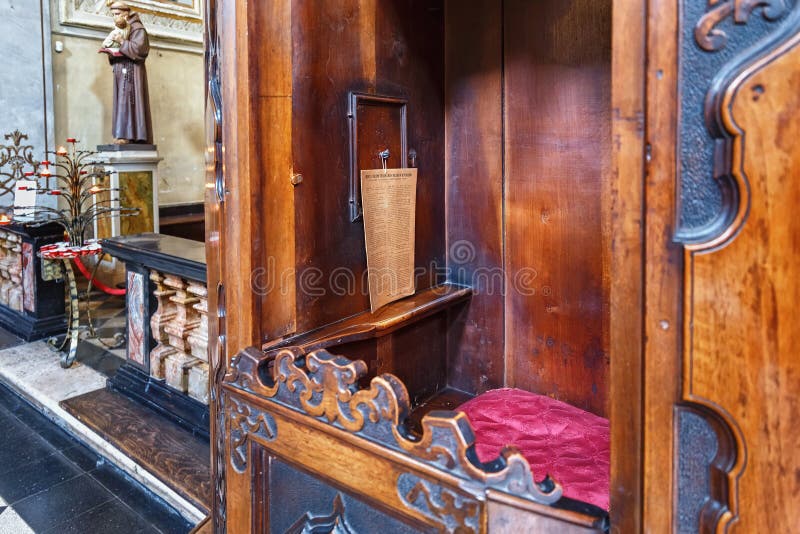 ERGAMO, ITALY - MAY 22, 2019: Place for priest in the old wooden confessional in the Catholic Church of Sant Agata nel Carmine in Bergamo. ERGAMO, ITALY - MAY 22, 2019: Place for priest in the old wooden confessional in the Catholic Church of Sant Agata nel Carmine in Bergamo.