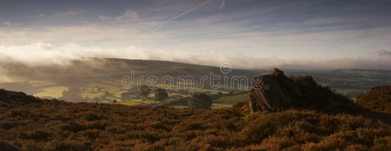 The early morning mist rolls over the heather of The Peak District moorland. Staffordshire, UK. The early morning mist rolls over the heather of The Peak District moorland. Staffordshire, UK.