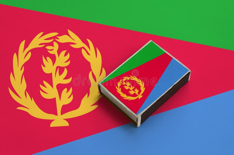 Eritrea flag is pictured on a matchbox that lies on a large flag royalty free stock photos