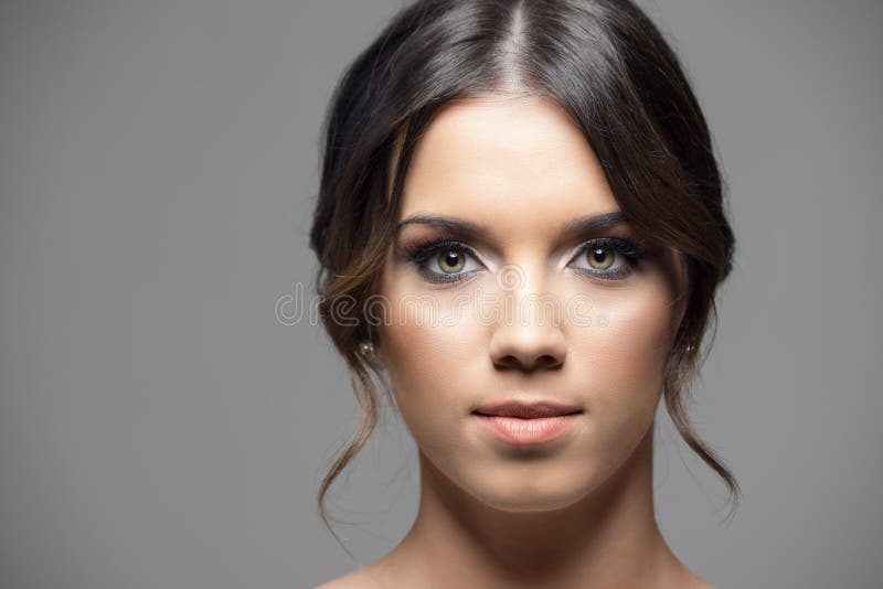 Ernste junge Frau mit grünen Augen und smokey mustert das Make-up, das Kamera betrachtet stockfotografie Ernste junge Frau mit grünen Augen und smokey mustert das Make-up, das Kamera betrachtet stockfotografie
