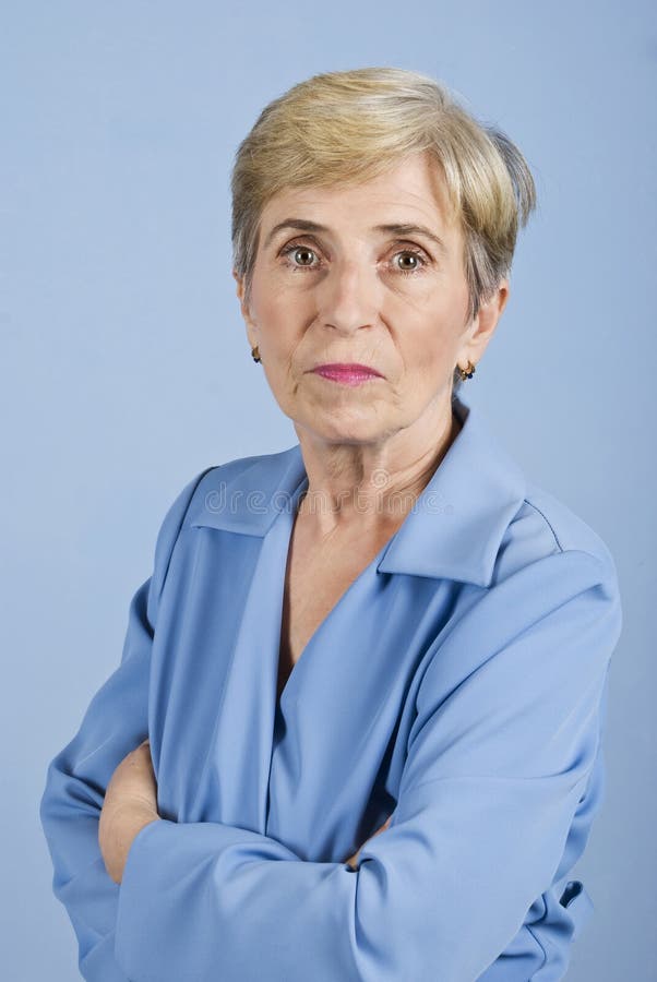 Senior business woman standing with arms crossed and looking at you isolated on blue background,check also Business people ,laptop and money. Senior business woman standing with arms crossed and looking at you isolated on blue background,check also Business people ,laptop and money