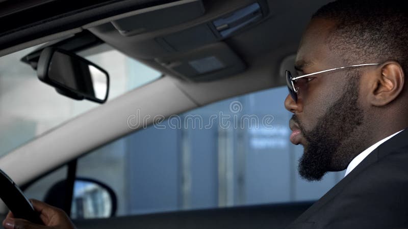 Ernster Afroamerikanermann, der das Automobil, aufmerksam betrachtend Straße fährt lizenzfreies stockbild Ernster Afroamerikanermann, der das Automobil, aufmerksam betrachtend Straße fährt lizenzfreies stockbild