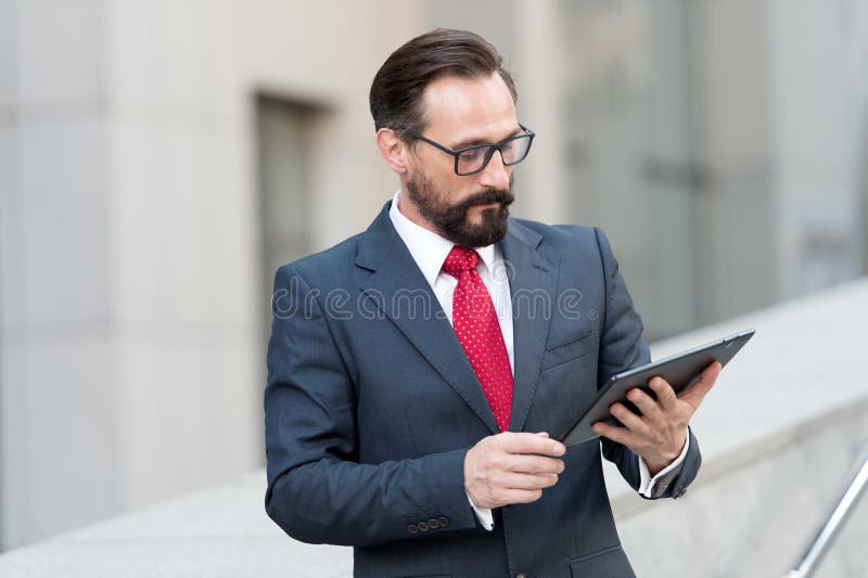 Ernster Immobilienmakler, der seine Tablette und Denken betrachtet lizenzfreies stockfoto Ernster Immobilienmakler, der seine Tablette und Denken betrachtet lizenzfreies stockfoto