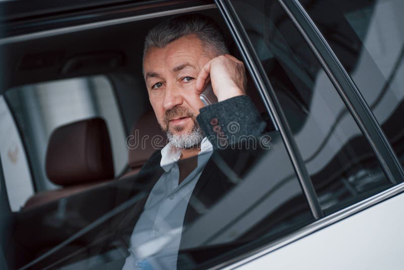 Ernstige bezige baas Zakelijke gesprekken in de auto terwijl ze gestopt zijn Het hebben van gesprek over nieuwe overeenkomsten royalty-vrije stock afbeelding Ernstige bezige baas Zakelijke gesprekken in de auto terwijl ze gestopt zijn Het hebben van gesprek over nieuwe overeenkomsten royalty-vrije stock afbeelding