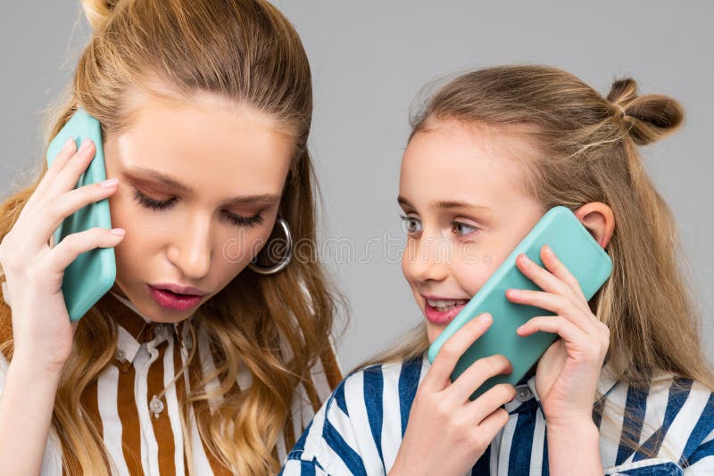 Ernstige mooie vrouw die belangrijk telefoongesprek hebben terwijl het blijven met haar zuster royalty-vrije stock afbeeldingen Ernstige mooie vrouw die belangrijk telefoongesprek hebben terwijl het blijven met haar zuster royalty-vrije stock afbeeldingen