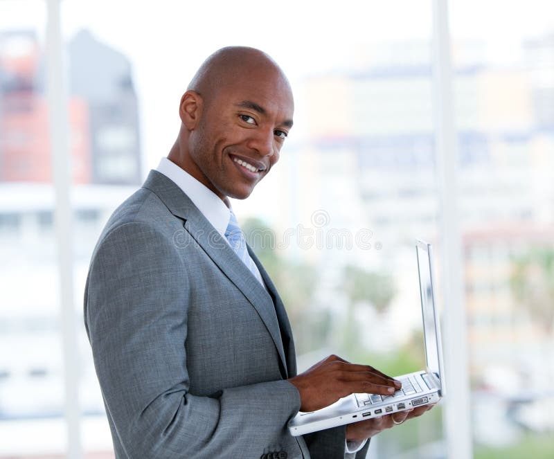 Portrait of a serious businessman working at a laptop in a company. Portrait of a serious businessman working at a laptop in a company