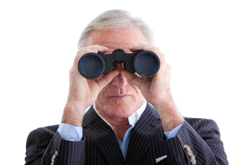 Serious businessman looking through binoculars standing against a white background. Serious businessman looking through binoculars standing against a white background