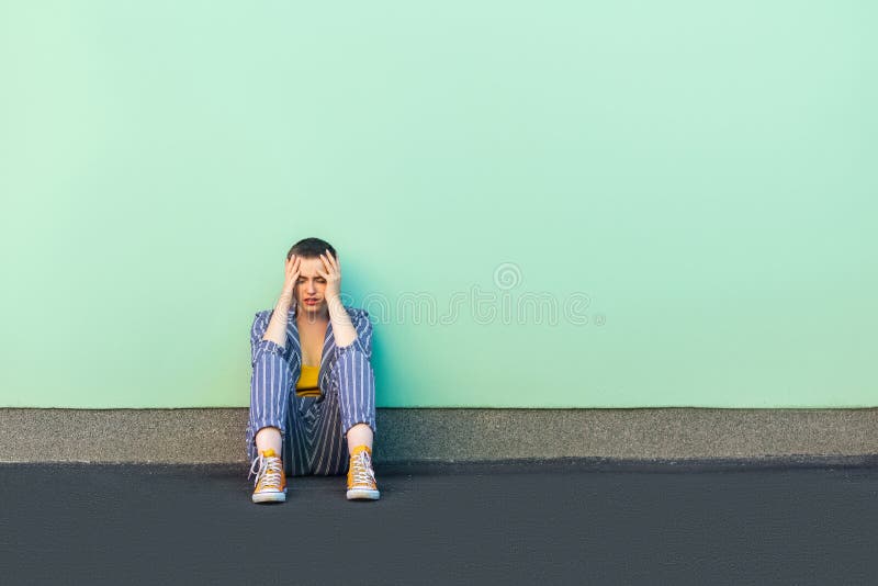 Error, tristeza o depresión Retrato de la mujer joven sola triste del pelo corto en el traje rayado casual que se sienta en piso, fotos de archivo libres de regalías Error, tristeza o depresión Retrato de la mujer joven sola triste del pelo corto en el traje rayado casual que se sienta en piso, fotos de archivo libres de regalías
