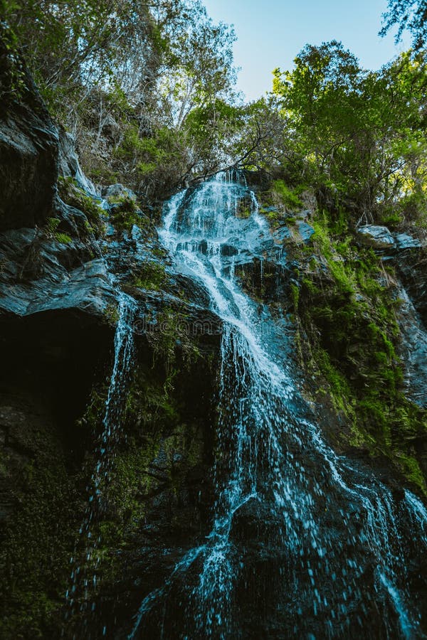 Erschossen von unter einem enormen Wasserfalls mitten in der Natur in einem Wald während eines regnerischen Tag lizenzfreie stockbilder