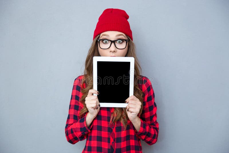 Erschrockene Frau, die ihr Gesicht mit Tablet-Computer bedeckt stockbild Erschrockene Frau, die ihr Gesicht mit Tablet-Computer bedeckt stockbild