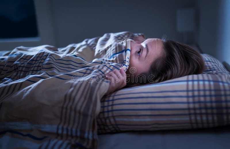 Erschrockene Frau, die unter Decke sich versteckt ?ngstlich von der Dunkelheit Unfähig, nach Albtraum oder Albtraum zu schlafen