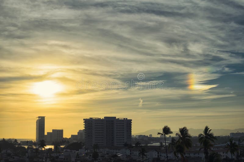 Erstaunlicher goldener Sonnenuntergang- und Feuerregenbogen über Puerto Vallarta lizenzfreies stockbild Erstaunlicher goldener Sonnenuntergang- und Feuerregenbogen über Puerto Vallarta lizenzfreies stockbild