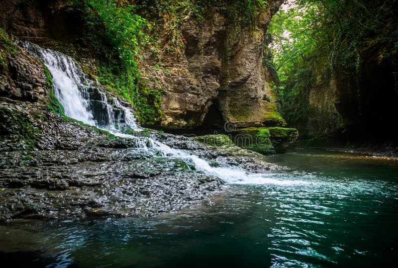 Erstaunlicher Waldwasserfall, der in den kalten Gebirgsfluss fließt Martvili-Schlucht Naturfall lizenzfreie stockbilder Erstaunlicher Waldwasserfall, der in den kalten Gebirgsfluss fließt Martvili-Schlucht Naturfall lizenzfreie stockbilder