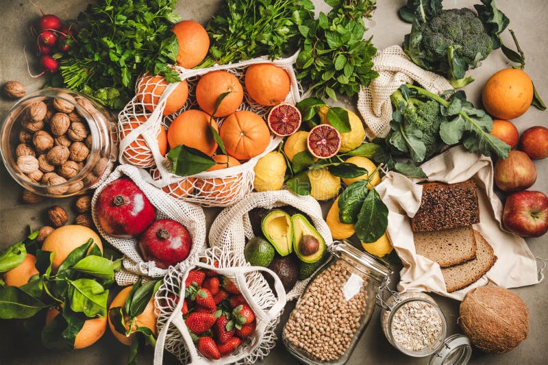 Assortment of vegan, vegetarian, balanced diet foods. Flat-lay of fruit, vegetables, nut, greens and essential products such as rye bread over grey concrete background, top view. Healthy, clean eating. Assortment of vegan, vegetarian, balanced diet foods. Flat-lay of fruit, vegetables, nut, greens and essential products such as rye bread over grey concrete background, top view. Healthy, clean eating