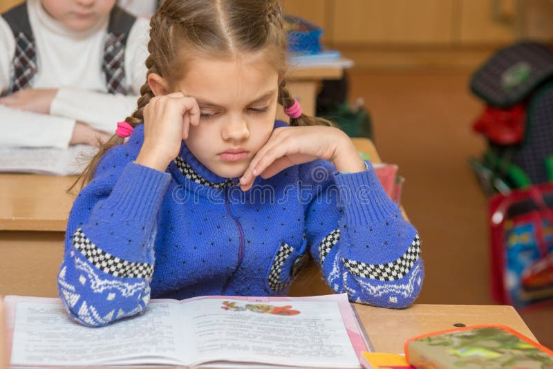 Erstes Sortierermädchen fühlt sich im Klassenzimmer in der Schule schlecht stockbild Erstes Sortierermädchen fühlt sich im Klassenzimmer in der Schule schlecht stockbild