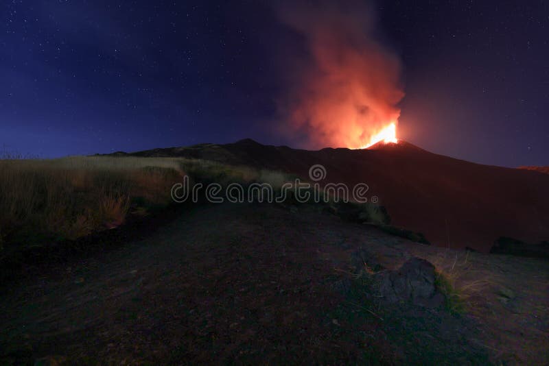 Panoramica del vulcano di Sicilia: Etna in eruzione durante la notte con sfondo il cielo stellato