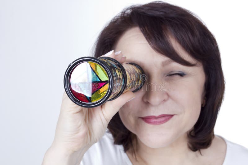 Erwachsene Frau, die ein Kaleidoskop untersucht stockbilder Erwachsene Frau, die ein Kaleidoskop untersucht stockbilder