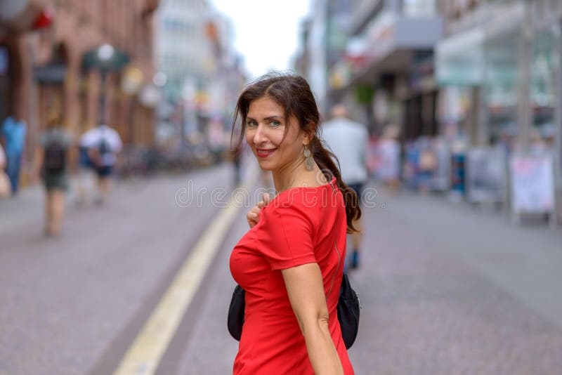 Erwachsene Frau, die über Schulter Kamera betrachtet lizenzfreies stockbild Erwachsene Frau, die über Schulter Kamera betrachtet lizenzfreies stockbild