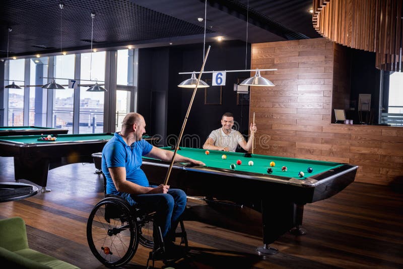 Erwachsene Männer mit Behinderung im Rollstuhl spielen Billard im Club lizenzfreies stockfoto