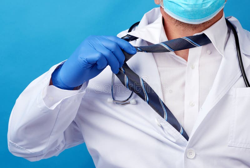 Erwachsene männlicher Arzt in einem weißen Jacke reißt seinen blauen Hintergrund der Anleihe auseinander stockfoto