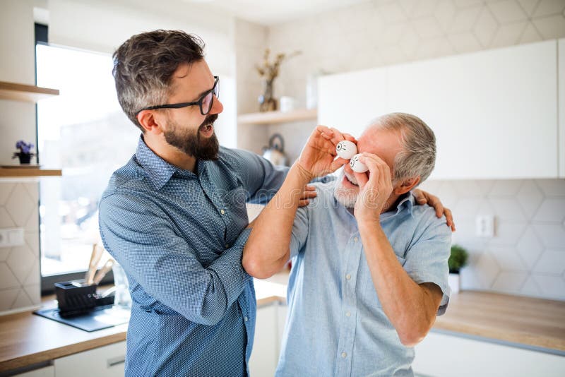 Erwachsener Hippie-Sohn und ?lterer Vater zuhause in der K?che zu Hause, Spa? habend stockfotografie Erwachsener Hippie-Sohn und ?lterer Vater zuhause in der K?che zu Hause, Spa? habend stockfotografie