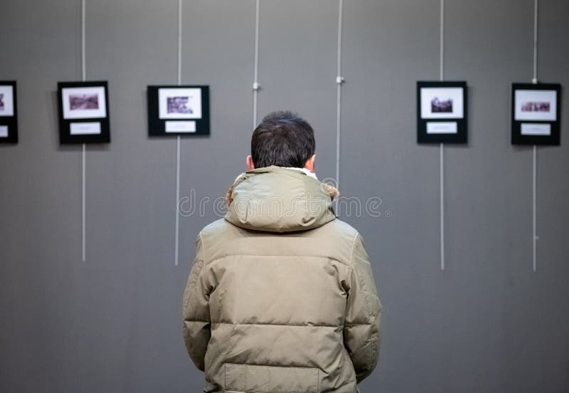 Erwachsener Kaukasier besucht Ausstellung in der modernen Kunstgalerie stockfotografie