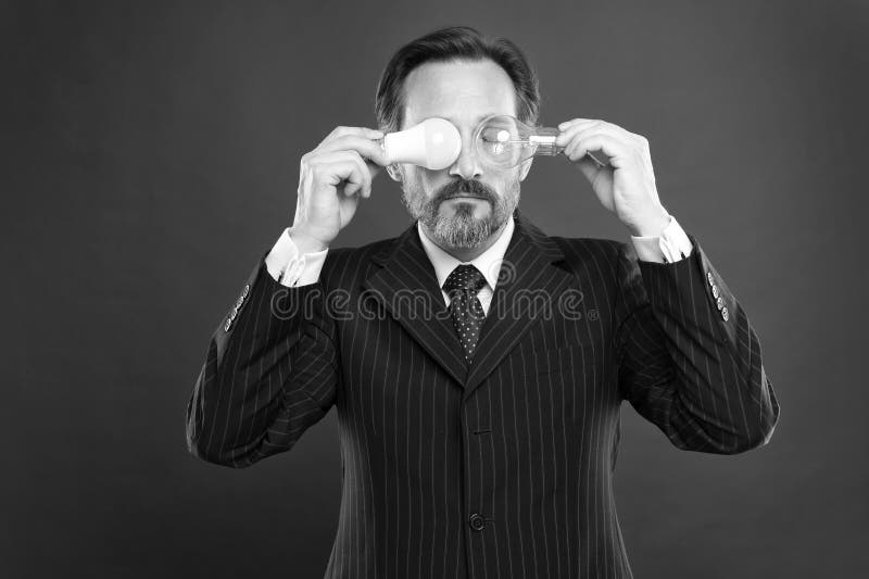 Erzeugung von kreativen Ideen Energieeinsparung verwirrter Mann in der Gesch? ftsausstattung Gesch? ftsmann in der Klagengriff-Gl? h lizenzfreie stockfotografie