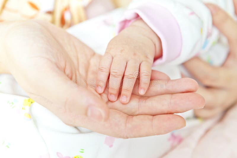 Primer de la mano del bebé que lleva a cabo la mano de la madre imagenes de archivo Primer de la mano del bebé que lleva a cabo la mano de la madre imagenes de archivo