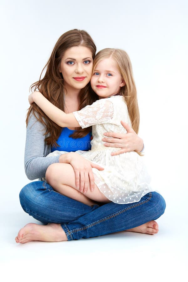 Es gibt 3 Mädchen und ihre Mutter, die auf der orange Couch sitzen Huging Tochter der Mutter stockfotos