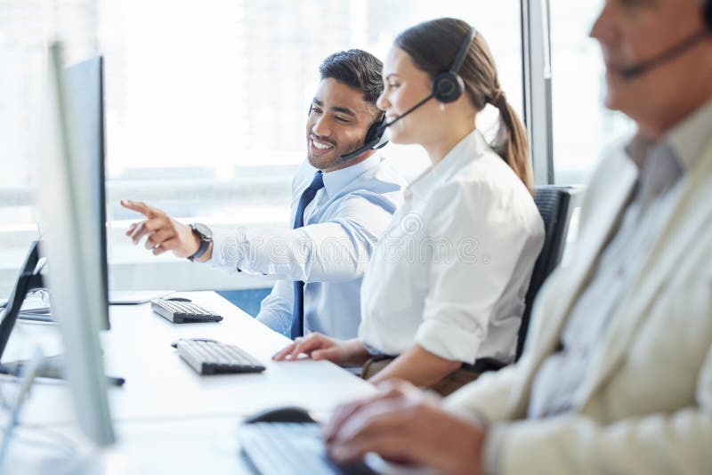 Es ist immer besser, Teil eines Teams zu sein. zwei Kollegen, die etwas diskutieren, während sie in einem Call Center arbeiten.