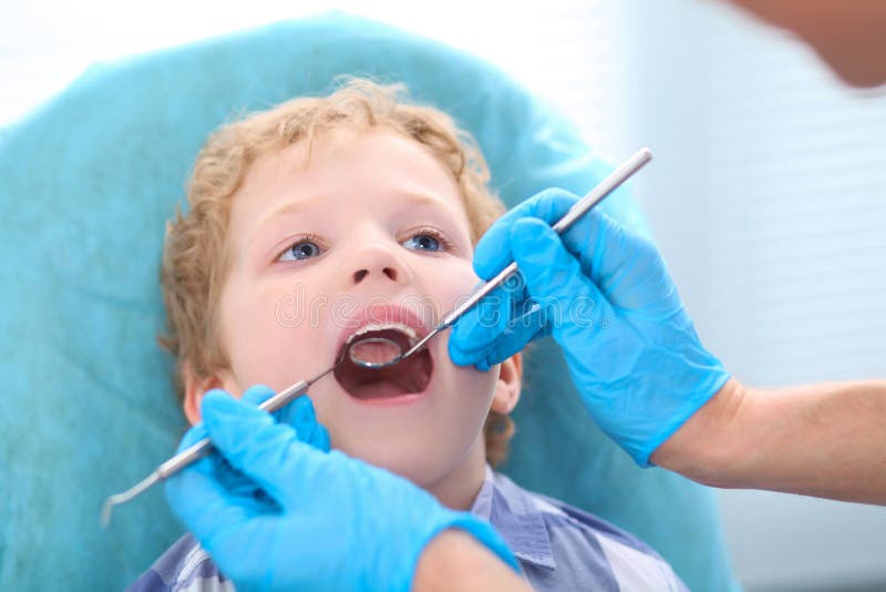 Esame del dentista denti dei ragazzini nella sedia dei dentisti alla clinica immagine stock Esame del dentista denti dei ragazzini nella sedia dei dentisti alla clinica immagine stock