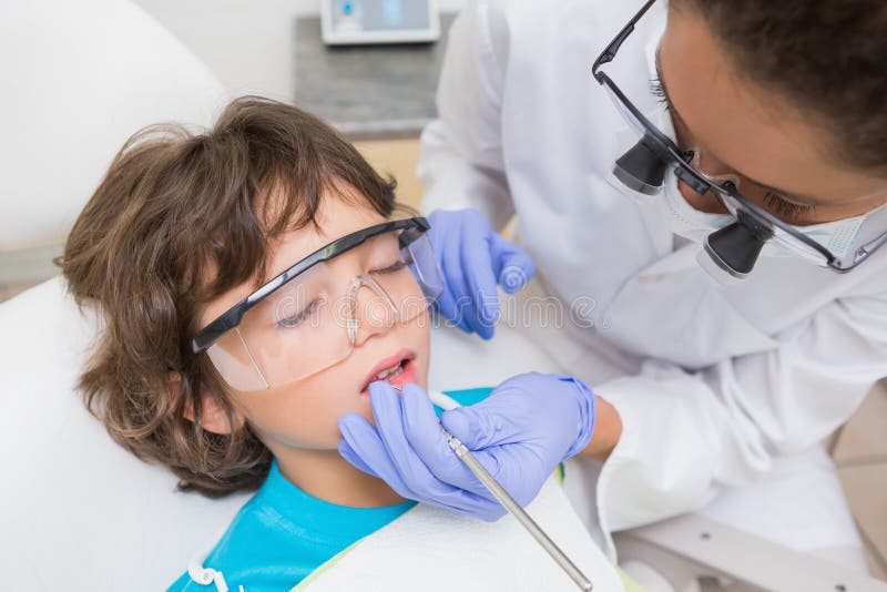 Esame pediatrico del dentista denti dei ragazzini nella sedia dei dentisti fotografie stock libere da diritti Esame pediatrico del dentista denti dei ragazzini nella sedia dei dentisti fotografie stock libere da diritti