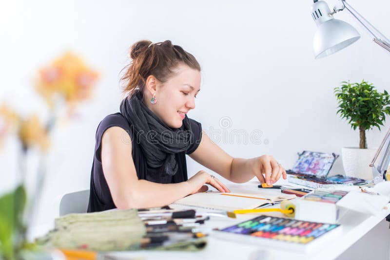 Esboço fêmea novo do desenho do artista usando o bloco de desenho com o lápis em seu local de trabalho no estúdio Retrato da vist fotos de stock Esboço fêmea novo do desenho do artista usando o bloco de desenho com o lápis em seu local de trabalho no estúdio Retrato da vist fotos de stock