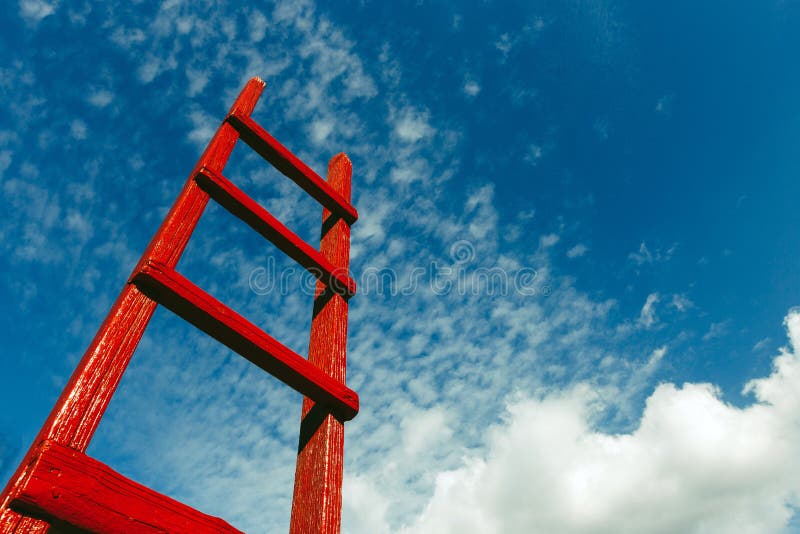 Escadaria de madeira vermelha contra o céu azul Conceito do crescimento do céu da carreira do negócio da motivação do desenvolvim