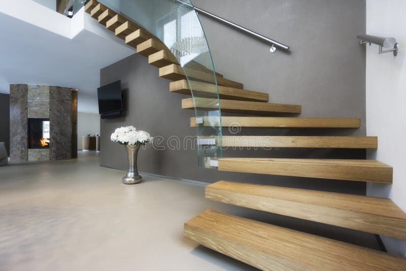 Escadaria elegante da madeira e do vidro na casa luxuosa