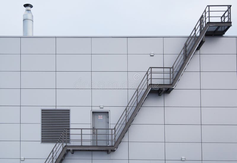 Escadaria industrial na fachada moderna de aço da telha