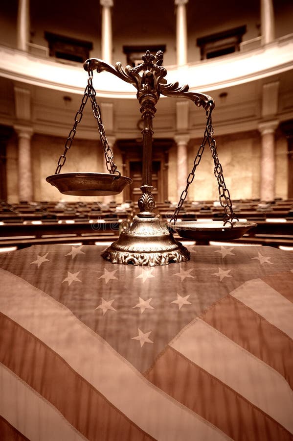 Escalas decorativas de la justicia en la sala de tribunal y la bandera de los Estados Unidos imágenes de archivo libres de regalías Escalas decorativas de la justicia en la sala de tribunal y la bandera de los Estados Unidos imágenes de archivo libres de regalías
