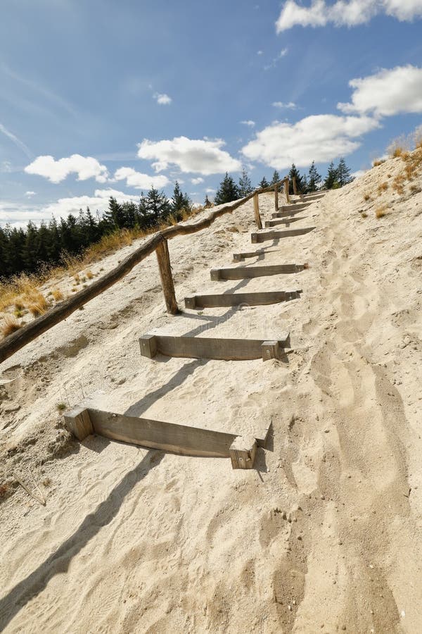 Escaleras de madera de la trayectoria en la arena hasta el cielo azul fotos de archivo Escaleras de madera de la trayectoria en la arena hasta el cielo azul fotos de archivo