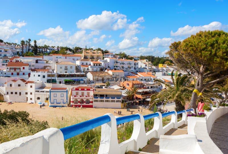 Escaliers menant à la plage sablonneuse entourée par les maisons blanches typiques, Carvoeiro, Algarve, Portugal image stock Escaliers menant à la plage sablonneuse entourée par les maisons blanches typiques, Carvoeiro, Algarve, Portugal image stock
