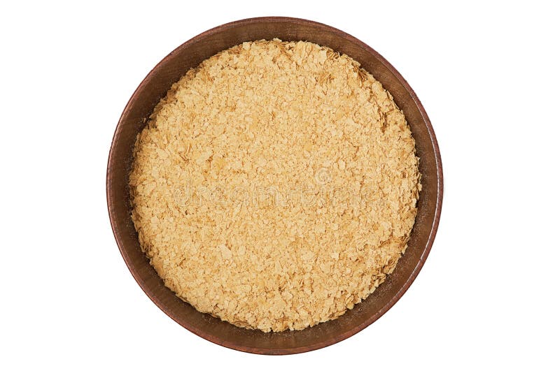 Nutritional brewers yeast flakes in wooden bowl isolated on white background. Top view. Nutritional brewers yeast flakes in wooden bowl isolated on white background. Top view