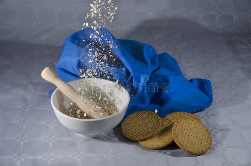 Escamas de la avena que caen en un cuenco y las galletas imagenes de archivo Escamas de la avena que caen en un cuenco y las galletas imagenes de archivo