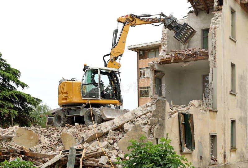 Escavador demolindo um antigo prédio para um redesenvolvimento urbano. imagens de stock royalty free