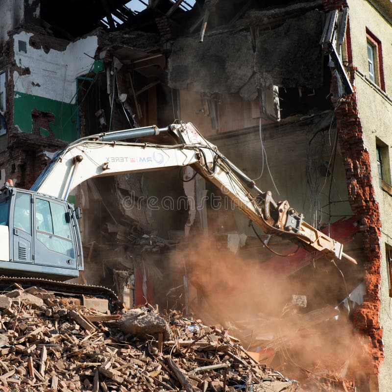 Escavador demolindo um edifício de tijolos. edifício de demolição de máquinas fotos de stock