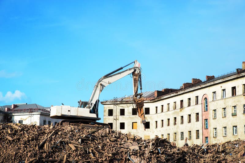 Escavador demolindo um edifício de tijolos. edifício de demolição de máquinas fotos de stock