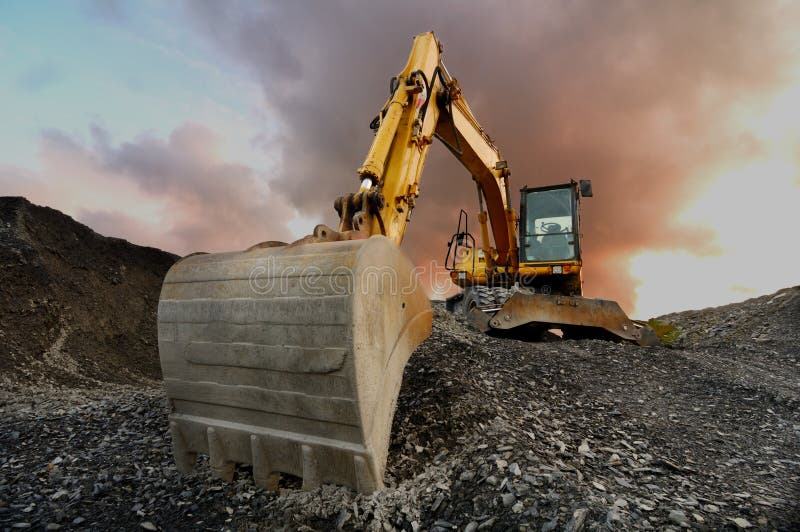 Image of a wheeled excavator on a quarry tip. Image of a wheeled excavator on a quarry tip