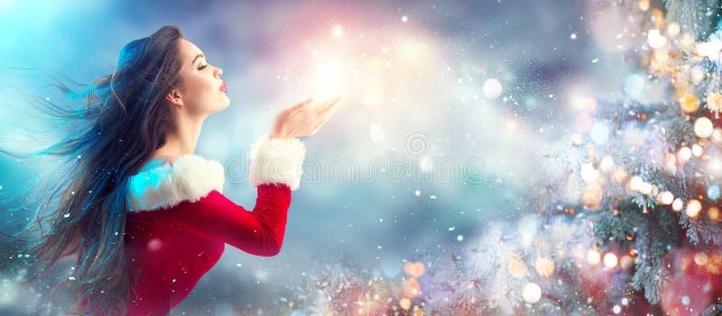 Escena de la Navidad Santa atractivo Mujer joven morena en nieve que sopla del traje del partido imagen de archivo Escena de la Navidad Santa atractivo Mujer joven morena en nieve que sopla del traje del partido imagen de archivo